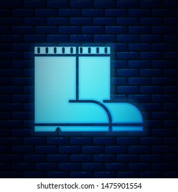Glowing neon Fishing boots icon isolated on brick wall background. Waterproof rubber boot. Gumboots for rainy weather, fishing, hunter, gardening.  Vector Illustration