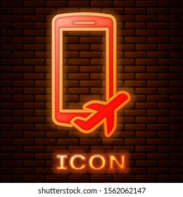 Glowing neon Flight mode in the mobile phone icon isolated on brick wall background. Airplane or aeroplane flight offline mode passenger regulation airline .  Vector Illustration