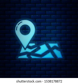 Glowing neon Folded map with location marker icon isolated on brick wall background.  Vector Illustration