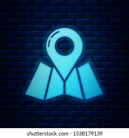 Glowing neon Folded map with location marker icon isolated on brick wall background.  Vector Illustration