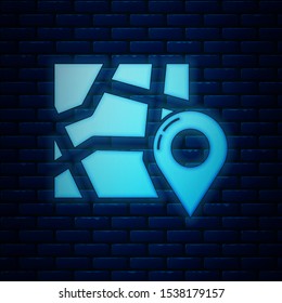 Glowing neon Folded map with location marker icon isolated on brick wall background.  Vector Illustration