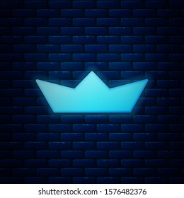 Glowing neon Folded paper boat icon isolated on brick wall background. Origami paper ship.  Vector Illustration