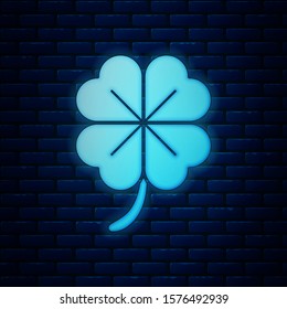 Glowing neon Four leaf clover icon isolated on brick wall background. Happy Saint Patrick day.  Vector Illustration