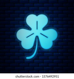 Glowing neon Four leaf clover icon isolated on brick wall background. Happy Saint Patrick day.  Vector Illustration