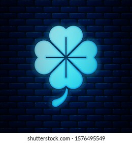 Glowing neon Four leaf clover icon isolated on brick wall background. Happy Saint Patrick day.  Vector Illustration