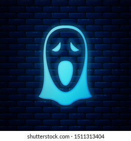 Glowing neon Funny and scary ghost mask for Halloween icon isolated on brick wall background. Happy Halloween party.  Vector Illustration
