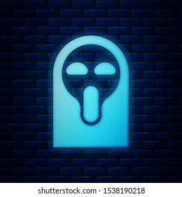Glowing neon Funny and scary ghost mask for Halloween icon isolated on brick wall background. Happy Halloween party.  Vector Illustration