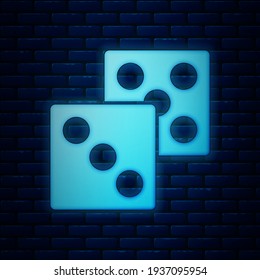 Glowing neon Game dice icon isolated on brick wall background. Casino gambling.  Vector