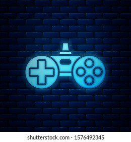 Glowing neon Gamepad icon isolated on brick wall background. Game controller.  Vector Illustration