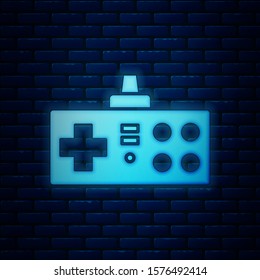 Glowing neon Gamepad icon isolated on brick wall background. Game controller.  Vector Illustration