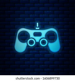 Glowing neon Gamepad icon isolated on brick wall background. Game controller.  Vector Illustration