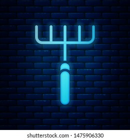 Glowing neon Garden rake icon isolated on brick wall background. Tool for horticulture, agriculture, farming. Ground cultivator. Housekeeping equipment.  Vector Illustration