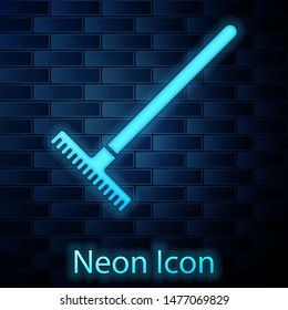 Glowing neon Garden rake icon isolated on brick wall background. Tool for horticulture, agriculture, farming. Ground cultivator. Housekeeping equipment.  Vector Illustration