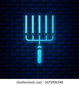 Glowing neon Garden rake in work icon isolated on brick wall background. Tool for horticulture, agriculture, farming. Ground cultivator.  Vector Illustration
