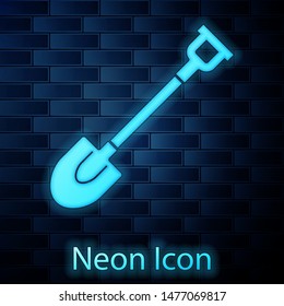 Glowing neon Garden shovel icon isolated on brick wall background. Gardening tool. Tool for horticulture, agriculture, farming.  Vector Illustration