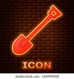 Glowing neon Garden shovel icon isolated on brick wall background. Gardening tool. Tool for horticulture, agriculture, farming.  Vector Illustration
