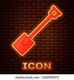 Glowing neon Garden shovel icon isolated on brick wall background. Gardening tool. Tool for horticulture, agriculture, farming.  Vector Illustration