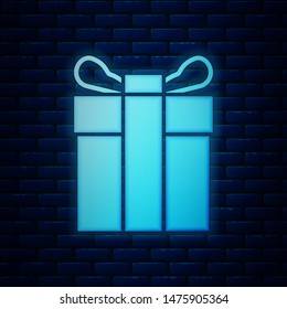 Glowing neon Gift box icon isolated on brick wall background.  Vector Illustration