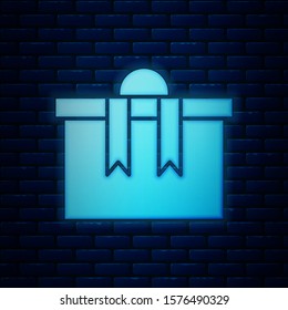 Glowing neon Gift box icon isolated on brick wall background. Merry Christmas and Happy New Year.  Vector Illustration