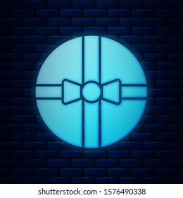 Glowing neon Gift box icon isolated on brick wall background. Merry Christmas and Happy New Year.  Vector Illustration