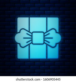 Glowing neon Gift box icon isolated on brick wall background.  Vector Illustration