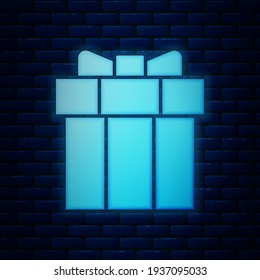 Glowing neon Gift box icon isolated on brick wall background. Valentines day.  Vector