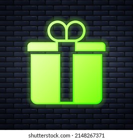 Glowing neon Gift box icon isolated on brick wall background. Merry Christmas and Happy New Year.  Vector