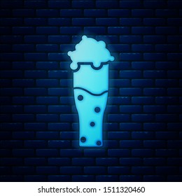 Glowing neon Glass of beer icon isolated on brick wall background.  Vector Illustration