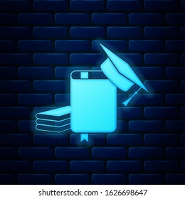 Glowing neon Graduation cap and book icon isolated on brick wall background.  Vector Illustration