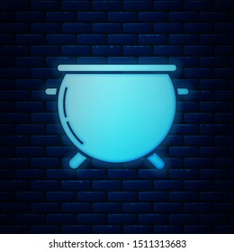 Glowing neon Halloween witch cauldron icon isolated on brick wall background. Happy Halloween party.  Vector Illustration