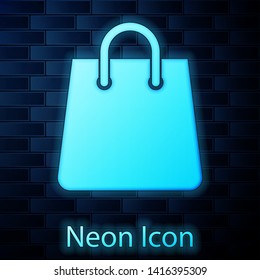 Glowing neon Handbag icon isolated on brick wall background. Shoping bag sign. Woman bag icon. Female handbag sign. Glamour casual baggage. Vector Illustration