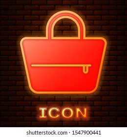 Glowing neon Handbag icon isolated on brick wall background. Female handbag sign. Glamour casual baggage symbol.  Vector Illustration