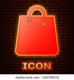 Glowing neon Handbag icon isolated on brick wall background. Shoping bag sign. Woman bag icon. Female handbag sign. Glamour casual baggage.  Vector Illustration