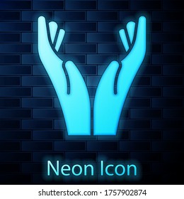 Glowing neon Hands in praying position icon isolated on brick wall background. Prayer to god with faith and hope. Vector Illustration