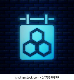 Glowing neon Hanging sign with honeycomb isolated on brick wall background. Signboard icon. Honey cells symbol. Sweet natural food.  Vector Illustration