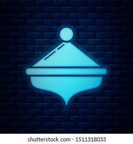 Glowing neon Hanukkah dreidel icon isolated on brick wall background.  Vector Illustration