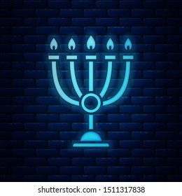 Glowing neon Hanukkah menorah icon isolated on brick wall background. Hanukkah traditional symbol. Holiday religion, jewish festival of Lights.  Vector Illustration