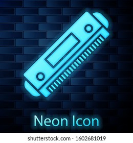 Glowing neon Harmonica icon isolated on brick wall background. Musical instrument.  Vector Illustration