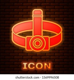 Glowing neon Head flashlight icon isolated on brick wall background. Tourist head flashlight. Camping head light.  Vector Illustration
