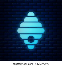 Glowing neon Hive for bees icon isolated on brick wall background. Beehive symbol. Apiary and beekeeping. Sweet natural food.  Vector Illustration