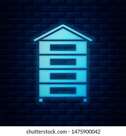 Glowing neon Hive for bees icon isolated on brick wall background. Beehive symbol. Apiary and beekeeping. Sweet natural food.  Vector Illustration