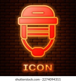 Glowing neon Hockey helmet icon isolated on brick wall background.  Vector