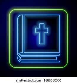 Glowing neon Holy bible book icon isolated on blue background.  Vector Illustration