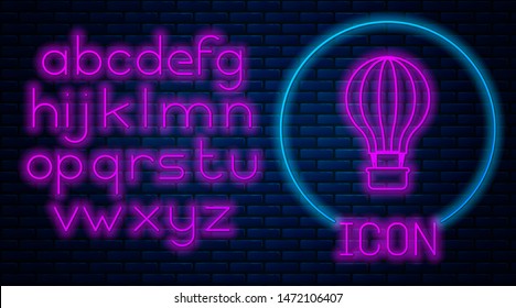 Glowing neon Hot air balloon icon isolated on brick wall background. Air transport for travel. Neon light alphabet. Vector Illustration