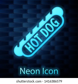 Glowing neon Hotdog sandwich icon isolated on brick wall background. Sausage icon. Fast food sign. Vector Illustration
