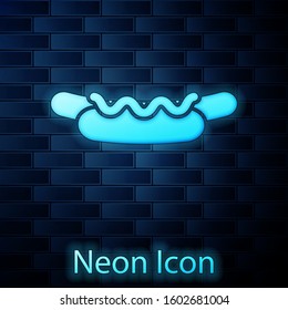 Glowing neon Hotdog sandwich with mustard icon isolated on brick wall background. Sausage icon. Street fast food menu.  Vector Illustration