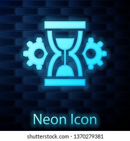 Glowing neon Hourglass and gear icon isolated on brick wall background. Time Management symbol. Clock and gear icon. Productivity symbol. Vector Illustration