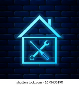 Glowing neon House or home with screwdriver and wrench icon isolated on brick wall background. Adjusting, service, setting, maintenance, repair, fixing.  Vector Illustration