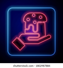 Glowing neon Human hand and easter cake icon isolated on blue background. Happy Easter.  Vector Illustration