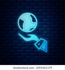 Glowing neon Human hands holding Earth globe icon isolated on brick wall background. Save earth concept.  Vector